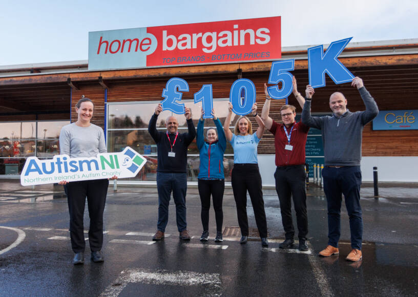 A group of people pose together outside a Home Bargains store