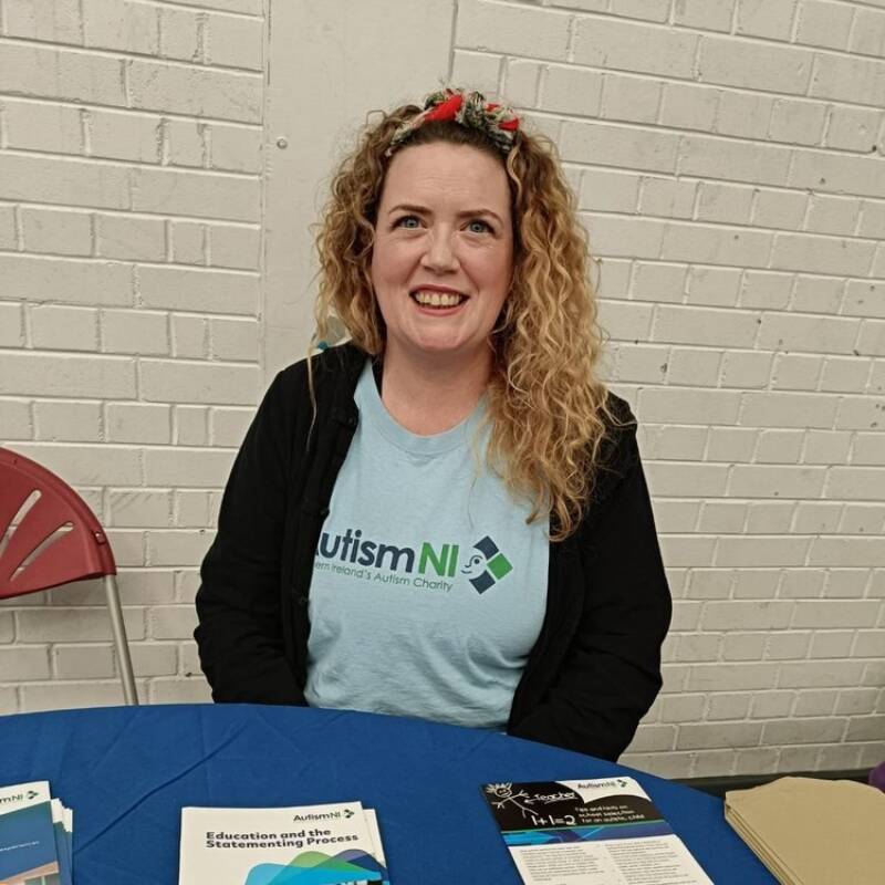 A woman smiling and wearing an Autism NI T-shirt
