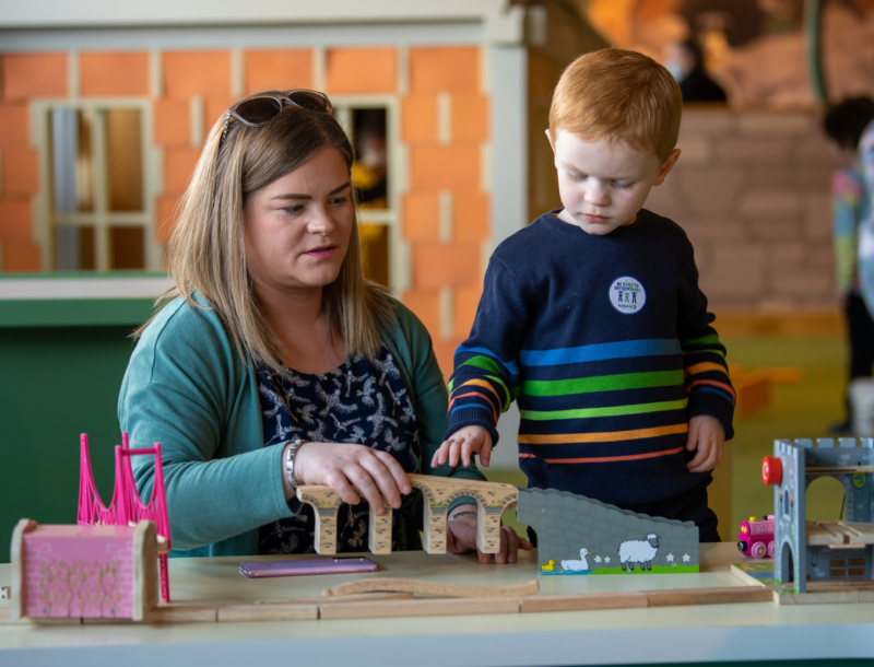 Mother and son play with toys together