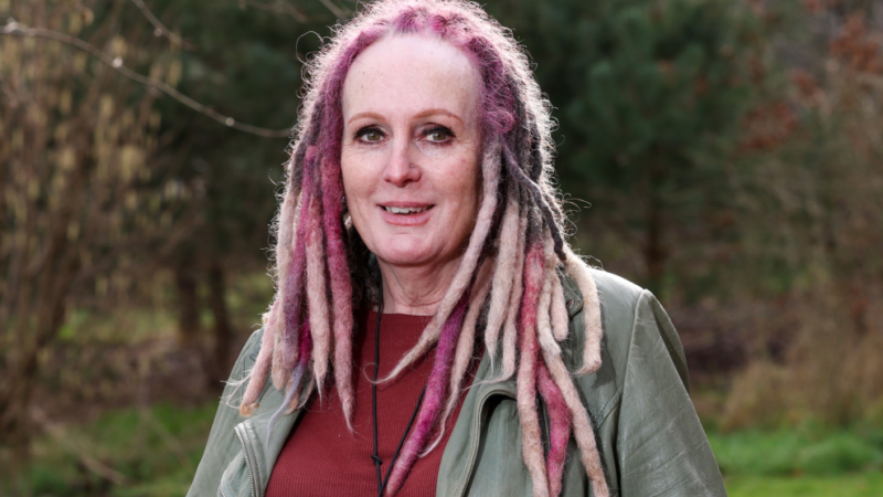 Woman smiles for a photograph while outdoors