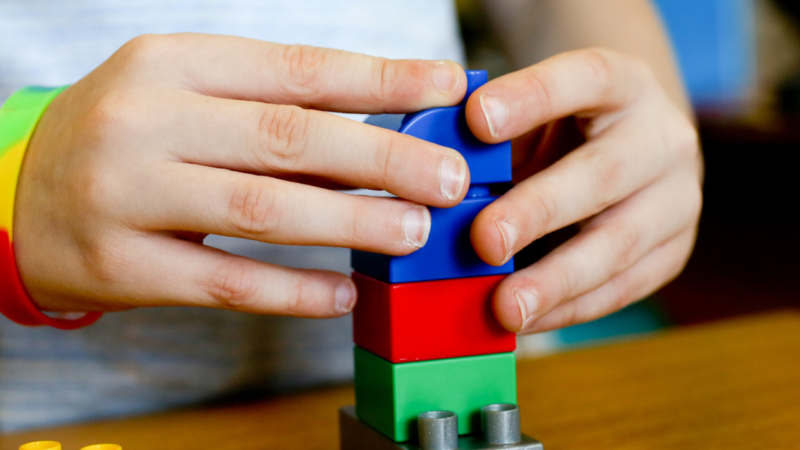 A child's hands using building blocks