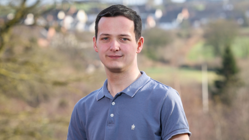 Young man outdoors smiling for a photograph