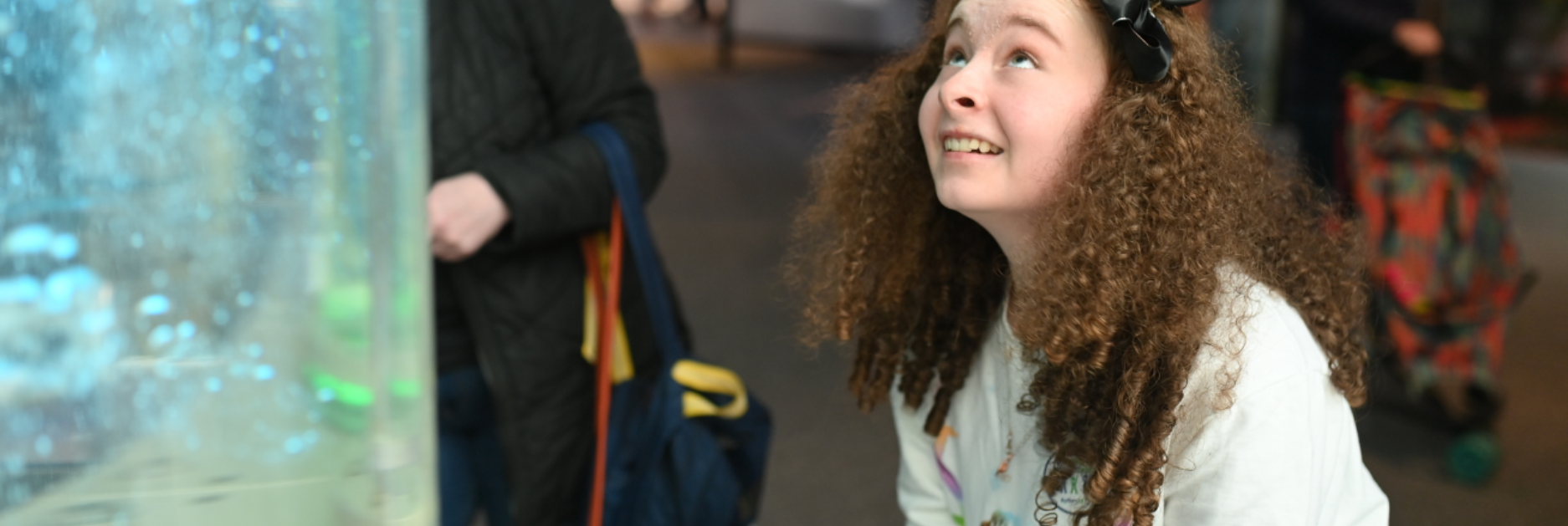 A young girl smiling and using an interactive bubbles display