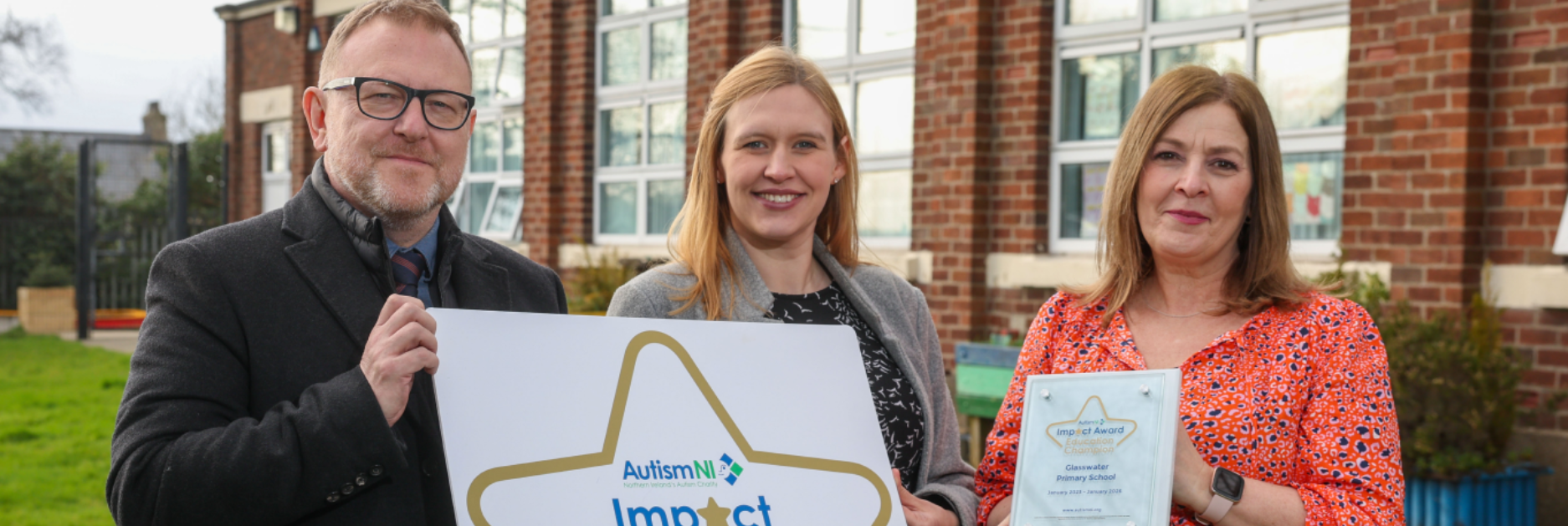 Several people smile and hold a sign that reads 'Impact Award Champion'