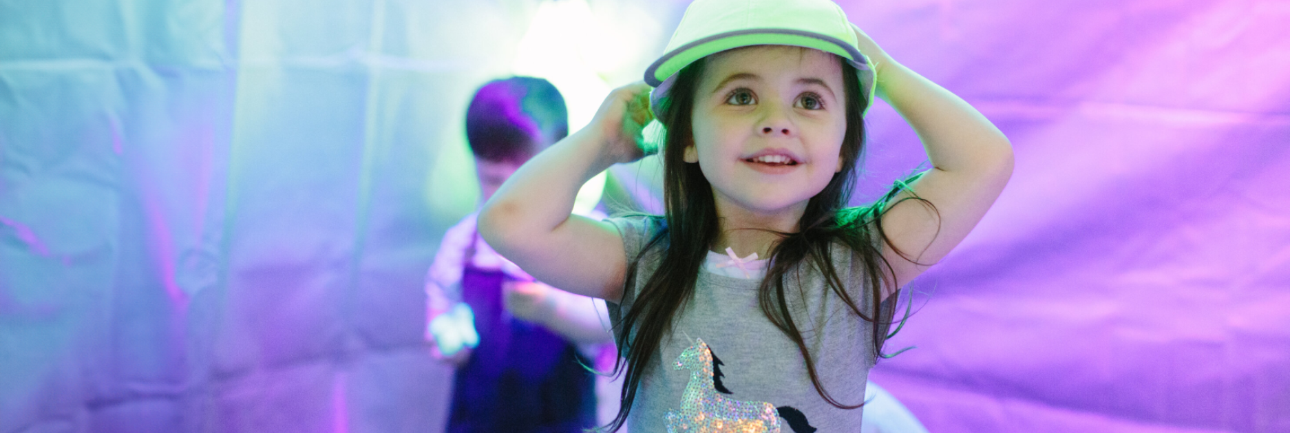 A small girl smiling and wearing a helmet