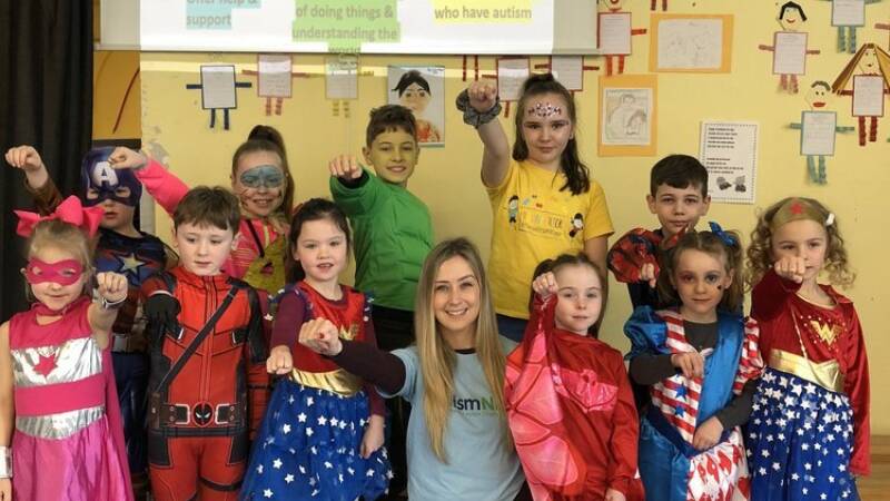 A group of children posing dressed as superheroes